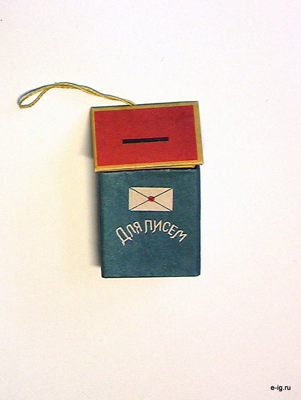 Собранный бирюзовый почтовый ящик с красной крышкой сверху и жёлтой петлёй.